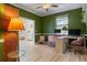 Bright and inviting home office with green walls, light wood floors, and a view into another room at 690 Cascading Creek Ln, Winter Garden, FL 34787