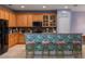 Kitchen with oak cabinets, stainless steel appliances, and an island with pink stools at 690 Cascading Creek Ln, Winter Garden, FL 34787