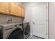 Well-lit laundry room with upper cabinets, patterned floor, and modern washer and dryer at 690 Cascading Creek Ln, Winter Garden, FL 34787