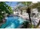 Inviting pool with tropical landscaping and a covered patio creating a serene outdoor space at 690 Cascading Creek Ln, Winter Garden, FL 34787