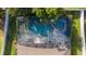 Aerial view of a screened-in pool and spa area with patio furniture surrounded by lush greenery at 690 Cascading Creek Ln, Winter Garden, FL 34787