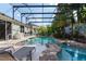 Backyard oasis showcasing a sparkling pool, spa, lush tropical landscaping, and covered patio at 690 Cascading Creek Ln, Winter Garden, FL 34787