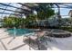Sparkling pool area featuring a hot tub, rock waterfall, lounge chairs, and lush landscaping at 690 Cascading Creek Ln, Winter Garden, FL 34787