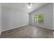 Bright bedroom featuring a window, neutral wall color, and wood-look tile flooring for easy maintenance at 1111 Brielle Ct, Oviedo, FL 32765