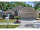 Charming single-story home featuring a manicured lawn and a two-car garage with a neutral color scheme at 1111 Brielle Ct, Oviedo, FL 32765