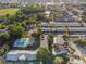 Expansive aerial view of a brick apartment complex featuring a pool, parking, and a court in a lush green area at 1227 Carriage Ln, Orlando, FL 32807