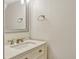 Stylish half-bathroom with a sleek mirror and modern vanity with granite countertop at 1227 Carriage Ln, Orlando, FL 32807