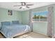 Bright bedroom showcasing a large window, ceiling fan, and soft carpeted floor at 1227 Carriage Ln, Orlando, FL 32807