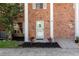 Charming brick townhome entrance with decorative wreath, manicured landscaping, and inviting curb appeal at 1227 Carriage Ln, Orlando, FL 32807