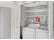 Functional laundry room featuring washer, dryer, and ample shelving for storage at 1227 Carriage Ln, Orlando, FL 32807