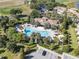 Aerial view of a resort-style community pool surrounded by lush landscaping and palm trees at 1339 Shinnecock Hills Dr, Davenport, FL 33896