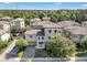 Townhome with a tile roof and brick driveway situated in a community surrounded by trees at 1339 Shinnecock Hills Dr, Davenport, FL 33896