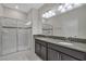 Bathroom with a large walk-in shower, double vanity, granite countertop, and white tiled floor at 1339 Shinnecock Hills Dr, Davenport, FL 33896