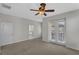 Spacious bedroom with a ceiling fan, neutral carpet, and access to a private balcony at 1339 Shinnecock Hills Dr, Davenport, FL 33896