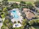 Aerial view of a sparkling community pool, hot tub, and clubhouse nestled amongst mature landscaping at 1339 Shinnecock Hills Dr, Davenport, FL 33896