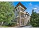 Beautiful three-story townhome with stone accents and dual balconies, enhanced by lush landscaping at 1339 Shinnecock Hills Dr, Davenport, FL 33896