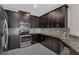 This kitchen features dark wood cabinets, stainless steel appliances, and granite countertops at 1339 Shinnecock Hills Dr, Davenport, FL 33896