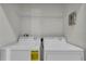 This laundry room features a washer, dryer and wire shelving at 1339 Shinnecock Hills Dr, Davenport, FL 33896
