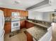 Open kitchen with granite countertops, white appliances, tile backsplash, and a breakfast bar at 13839 Fairway Island Dr # 1128, Orlando, FL 32837