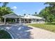 Charming home with covered parking, a metal roof, and paver driveway in a well-manicured yard at 1405 Pioneer Trl, New Smyrna Beach, FL 32168