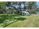 Large front yard featuring a beautiful shade tree with Spanish moss and a charming home at 1405 Pioneer Trl, New Smyrna Beach, FL 32168