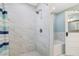 Shower with marble tile surround and glass doors at 1405 Pioneer Trl, New Smyrna Beach, FL 32168