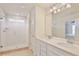 Bathroom featuring double sinks, granite countertops, and a glass door shower at 14374 Lanikai Beach Dr, Orlando, FL 32827