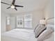Light and airy bedroom featuring a ceiling fan, queen size bed, and two windows at 14374 Lanikai Beach Dr, Orlando, FL 32827