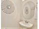 Powder room featuring decorative wall art, sink, and round mirror at 14374 Lanikai Beach Dr, Orlando, FL 32827