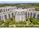 Expansive aerial view of the building exteriors with balconies, green spaces, and a lake in the background at 14501 Grove Resort Ave # 3335, Winter Garden, FL 34787