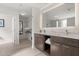 Bathroom featuring double sinks, lighted mirror, and storage shelves, with a walk-in closet at 14501 Grove Resort Ave # 3335, Winter Garden, FL 34787