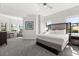 Sunlit bedroom showcases a sitting area, gray carpeting, and a comfortable king-sized bed at 14501 Grove Resort Ave # 3335, Winter Garden, FL 34787