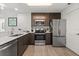 Modern kitchen featuring stainless steel appliances, wooden floors, and dark brown cabinets at 14501 Grove Resort Ave # 3335, Winter Garden, FL 34787