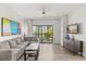 Bright living room with a plush gray sofa, modern furnishings, and balcony access at 14501 Grove Resort Ave # 3335, Winter Garden, FL 34787