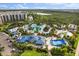 Stunning aerial view of the resort pool, lazy river, and water slides surrounded by lush tropical landscaping at 14501 Grove Resort Ave # 3335, Winter Garden, FL 34787