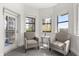 Inviting sitting area with two comfortable armchairs by the windows and balcony door at 14501 Grove Resort Ave # 3335, Winter Garden, FL 34787