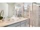 Elegant bathroom with double sinks, a large mirror, and a glass-enclosed shower featuring neutral tiles and finishes at 1624 Tropical Palms Cir, Kissimmee, FL 34747