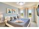 Bedroom showcasing a king-sized bed with elegant gray bedding and natural light at 1624 Tropical Palms Cir, Kissimmee, FL 34747