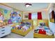 Bright ' bedroom with two twin beds, Mickey Mouse wall decor, and a small side table at 1624 Tropical Palms Cir, Kissimmee, FL 34747