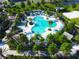 Aerial view of a luxurious community pool with chairs, umbrellas, and tropical landscaping at 1624 Tropical Palms Cir, Kissimmee, FL 34747