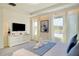 Bright main bedroom featuring a sleek TV console, neutral tones, and ample natural light from large windows at 1624 Tropical Palms Cir, Kissimmee, FL 34747