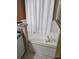 Close-up of a bathtub with white tile surround and shower curtain at 1639 Nestlewood Trl, Orlando, FL 32837