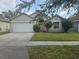 Charming single-story home featuring a well-manicured front yard and attached two car garage at 1639 Nestlewood Trl, Orlando, FL 32837