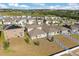 Aerial view of neighborhood homes showcasing rooftops and backyard spaces with a lake visible in the distance at 1830 Juneberry St, Clermont, FL 34715