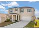 Two-story home with a two-car garage, porch, and green shutters under a blue and cloudy sky at 1830 Juneberry St, Clermont, FL 34715