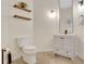 Powder room with vanity, open wood shelves, dark fixtures, toilet and stone floors at 1906 Oakbrook Dr, Longwood, FL 32779