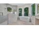 Bathroom featuring travertine flooring, large soaking tub, walk-in shower and natural light at 1906 Oakbrook Dr, Longwood, FL 32779