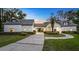 Elegant home showcasing a manicured front yard, porte cochere, and a paver driveway at dusk at 1906 Oakbrook Dr, Longwood, FL 32779
