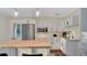 Modern kitchen features white cabinetry, stainless steel appliances, and an eat-in island with a wooden countertop at 1906 Oakbrook Dr, Longwood, FL 32779