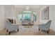 Bright living room with stone fireplace, decorative chandelier, and large windows overlooking the backyard at 1906 Oakbrook Dr, Longwood, FL 32779